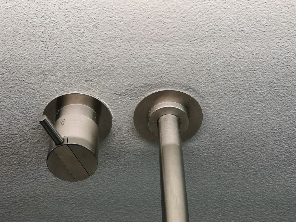 Stor bule i væggen ved vægarmatur under spejl med indbygget lys